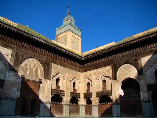 The Bou Inania Madrasa in Fes — the 14th-century theological school whose carved cedar, stucco plasterwork and zellige tilework represent one of the finest surviving expressions of the Andalusian-Moroccan decorative tradition