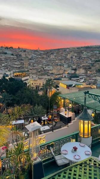 Rooftop terrace view over Fez el-Bali at dusk — staying in the medina places visitors in the heart of the festival atmosphere