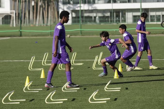 Young players train with cones and hurdles on the pitches of the Mohammed VI Football Academy near Rabat