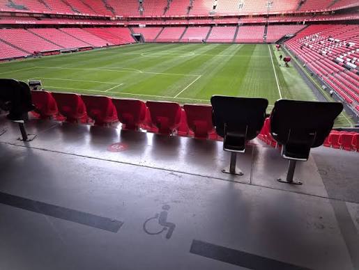 A wheelchair user follows a football match from an accessible stadium area.