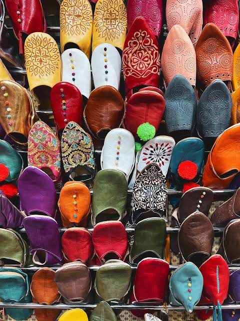 Colourful Moroccan leather babouches displayed together on racks